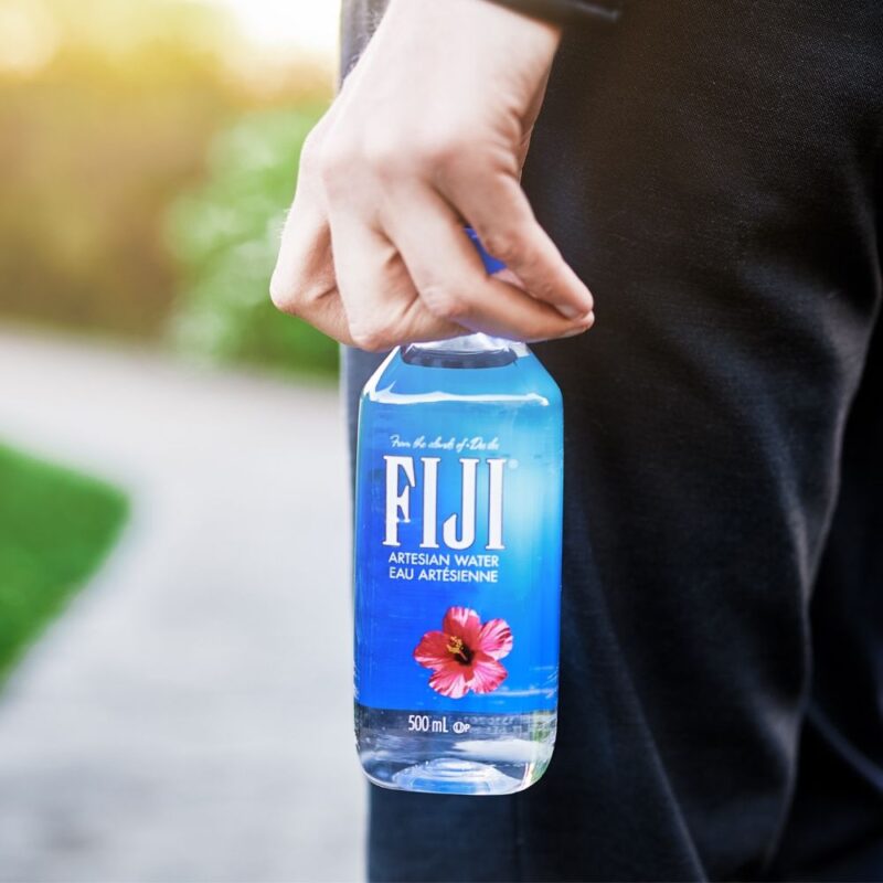 Mand holder en Fiji water på 500 ml i hånden